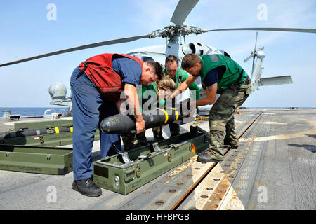 U.S. FIFTH FLEET AREA OF RESPONSIBILITY (Oct. 21, 2012) Sailors assigned to the Proud Warriors of Helicopter Anti-submarine Squadron Light (HSL) 42, Det. 7, lower an AGM-114N Hellfire missile into a case on the flight deck of the guided-missile destroyer USS Jason Dunham (DDG 109). Jason Dunham is deployed to the U.S. 5th Fleet area of responsibility conducting maritime security operations, theater security cooperation efforts and support missions for Operation Enduring Freedom. America’s Sailors are Warfighters, a fast and flexible force deployed worldwide. Join the conversation on social med Stock Photo