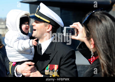 110302-N-8467N-005 GROTON, Conn. (March 2, 2011) Lt. j.g. Jeremy Leazer gets his picture taken with his 14-month-old daughter by his wife moments after the fast attack submarine USS Memphis (SSN 691) returned home to Naval Submarine Base New London. Memphis completed its final overseas mission to the U.S. European Command area of responsibility and is scheduled to be decommissioned at Submarine Base New London April 1. (U.S. Navy photo by John Narewski/Released)  - Official U.S. Navy Imagery - Sailor takes picture with daughter after USS Memphis returned home. Stock Photo