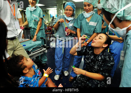 120801-O-ZZ999-002 SIHANOUKVILLE, Cambodia (Aug. 1, 2012) Hospital Corpsman 3rd Class Priscilla Saintcyr blows bubbles for a Cambodian boy before surgery aboard the Military Sealift Command hospital ship USNS Mercy (T-AH 19) during Pacific Partnership 2012. Cambodia is the final mission port for Pacific Partnership 2012; previous mission ports included Indonesia, Philippines and Vietnam. Pacific Partnership, an annual U.S. Pacific Fleet humanitarian and civic assistance mission now in its seventh year, brings together U.S. military personnel, host and partner nations, non-government organizati Stock Photo