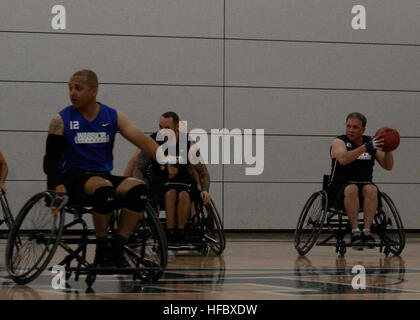 Team Navy/Coast Guard member, retired Lt Rikey Bennett, of Aurora, Colo. commands the ball during a game of wheelchair basketball against Team Air Force, May 14 at the 2013 Warrior Games. The Warrior Games includes competitions in archery, cycling, seated volleyball, shooting, swimming, track and field, and wheelchair basketball. The goal of the Warrior Games is not necessarily to identify the most skilled athletes, but rather to demonstrate the incredible potential of wounded warriors through competitive sports. More than 200 wounded, ill, or injured service members from the U.S. and U.K. arm Stock Photo