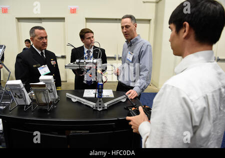 160516-N-PO203-114 NATIONAL HARBOR, Md. (May. 16, 2016) Mike Osborn, second from right, program manager, Naval Research Laboratory, explains the Meso-scale Robotic Locomotion Initiative (MeRLIn) to Rear Adm. Mat Winter, chief of naval research, during a visit to the Office of Naval Research exhibit at the 2016 Sea-Air-Space Exposition. Sea-Air-Space is hosted by the Navy League of the United States with the goal of bringing together leaders from defense organizations, both government and private industry, to learn about and view the most up-to-date information and technology related to maritim Stock Photo