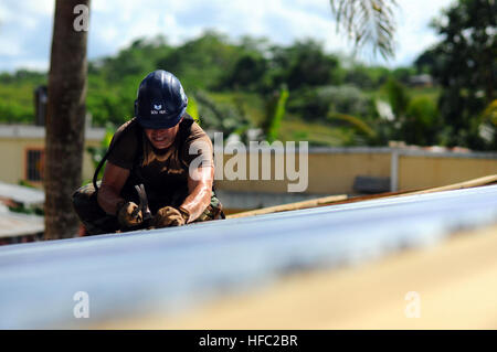 Air Force Tech Sgt. Scott Boucher, a civil engineer embarked aboard the amphibious assault ship USS Kearsarge, works on the roof of a school house being built during the humanitarian/civic assistance mission Continuing Promise 2008. Kearsarge is supporting the Caribbean phase of the humanitarian/civic assistance mission CP, an equal-partnership mission involving the United States, Canada, the Netherlands, Brazil, France, Nicaragua, Colombia, Dominican Republic, Trinidad and Tobago and Guyana. Helping to build a school 122515 Stock Photo
