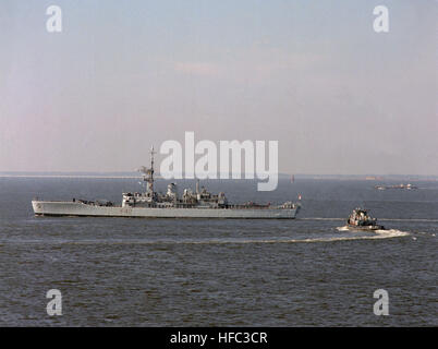 The large harbor tug Marinette (YTB-791) comes about to escort the Britisn frigate HMS Phoebe (F-42) into Naval Station, Norfolk, VA. HMS Phoebe F42 off NorfolkVA 1990 Stock Photo