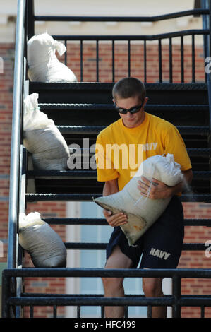 A U.S. Navy student at Naval Aviation Schools Command at Naval Air Station Pensacola, Fla., carries a sandbag in preparation for Tropical Storm Isaac Aug. 26, 2012. The storm was expected to make landfall along the Gulf Coast Aug. 28, 2012. The last major storm to affect northwest Florida was Hurricane Dennis, a Category 3 hurricane, which made landfall near Pensacola July 10, 2005. Isaac developed as a tropical storm over the western Atlantic Ocean Aug. 21, 2012, affecting Puerto Rico, the Dominican Republic, Haiti and Cuba before making landfall as a hurricane on the Gulf Coast of the United Stock Photo