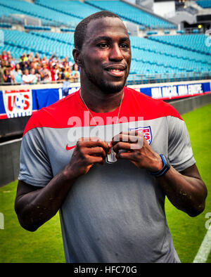 140606-N-MJ645-312 JACKSONVILLE, Fla. (June 6, 2014) Jozy Altidore, forward on the U.S. Men's National Soccer Team, holds in his hands custom 2014 World Cup dogtags presented to each member of the soccer team by servicemembers following an open-practice for fans at Everbank Stadium. (U.S. Navy photo by Mass Communication Specialist 2nd Class Marcus L. Stanley/Released) Jozy Altidore USMNT with dog tag Stock Photo