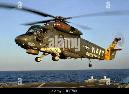 A left front view of a Helicopter Light Anti-submarine Squadron 30 (HSL-30) SH-2F Sea Sprite helicopter preparing to land on the helicopter pad of the destroyer USS NICHOLSON (DD-982). Kaman Seasprite 3 USAF Maxwell AFB Stock Photo