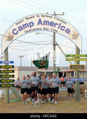 GUANTANAMO BAY, Cuba – Army Lt. Col. Alexander Conyers (left of flag) and Army Command Sgt. Maj. Steven Raines (right of right), with the 525th Military Police Battalion, lead the battalion on a run at Joint Task Force Guantanamo, July 7, 2010. The 525th MP Battalion provides a portion of the guard force at JTF Guantanamo. JTF Guantanamo provides safe, humane, legal and transparent care and custody of detainees, including those convicted by military commission and those ordered released by a court. The JTF conducts intelligence collection, analysis and dissemination for the protection of detai Stock Photo