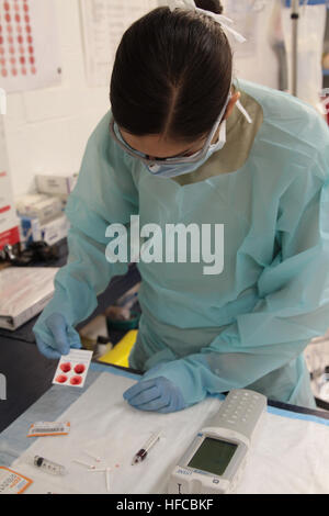 U.S. Army 1st Lt. Suzanne Laux, operating room nurse for the 541st Forward Surgical Team (FST) (Airborne), performs a laboratory exam in order to determine the blood type of an Afghan man on FOB Farah, Dec. 26.  The man was treated at FOB Farah by the FST following an IED blast during a mounted patrol in Farah province.  The man was treated and evacuated for further care.  (U.S. Navy photo by HMC Josh Ives/released) Medical casualty treatment on FOB Farah 121226-N-IE116-078 Stock Photo