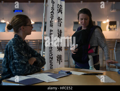 Damage Controlman 3rd Class assists personnel at Naval Air Facility Atsugi in registering for the Computer Desktop Notification System, which provides emergency and natural disaster alerts to base members. Stock Photo