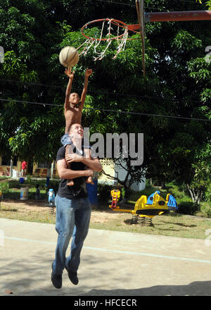 Lance Cpl. Mark Valanawski plays basketball with a local child at the St. Elisabeth orphanage. More than 50 Sailors and Marines from USS Nassau volunteered to help paint the interior of the orphanage as well as play with some of the children there. Nassau is the command platform for the Nassau Amphibious Ready Group and 24th Marine Expeditionary Unit, currently supporting Maritime Security Operations and Theater Security Cooperation Operations in the U.S. 5th Fleet area of responsibility. (U.S. Navy photo by Petty Officer 2nd Class Patrick Gordon) Nassau Sailors and Marines Volunteer in Seyche Stock Photo