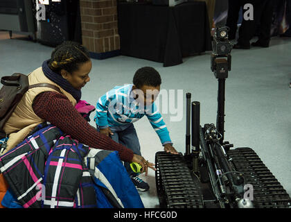 A student eagerly observes the MK II Talon robot at the Portsmouth Public Schools Science, Technology, Engineering, and Mathematics (STEM) Day event held at Woodrow Wilson High School. Sailors from Explosive Ordnance Disposal Mobile Unit (EODMU) 6 and Mobile Diving and Salvage Unit (MDSU) 2 supported the community outreach by providing an opportunity for students and their families to view and interact with Navy EOD and Navy Dive equipment and robots at the event. (U.S. Navy photo by Mass Communication Specialist 3rd Class Randy Savarese/Released) Navy EOD, divers promote science, technology w Stock Photo