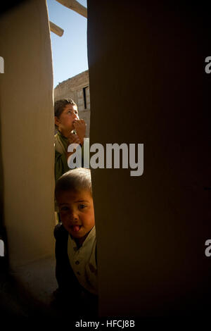 Children stand in the courtyard of their home as Afghan National Army Commandos from the 6th Commando Kandak conduct a clearing operation in Sayed Abad district, Wardak province, May 27. ANA Commandos, partnered with coalition forces, are leading combat operations in the surrounding areas of the Wardak province to disrupt insurgent safe havens and promote security in the area. OEF, ALLMASS 020 120527-N-WR307-347 Stock Photo