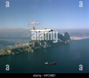 Aerial starbord view of a Patrol Squadron Forty-four (VP-44) P-3C Orion Anti-Submarine Warfare (ASW) aircraft  in flight to right.  The P-3Cis in flight to Naval Air Station (NAS) Keflavik (Iceland) from NAS Brunswick, Maine.  A Super Tanker underway and the Mediterranean side of the Island of Gibralter is visable in the background. P-3C Orion VP-44 over Gibraltar c1986 Stock Photo