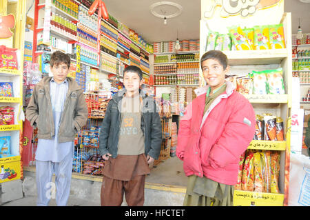 Afghan boys pose for a photo outside a candy shop in Farah City, Dec. 19.  PRT Farah's mission is to train, advise, and assist Afghan government leaders at the municipal, district, and provincial levels in Farah province, Afghanistan.  Their civil military team is comprised of members of the U.S. Navy, U.S. Army, the U.S. Department of State and the U.S. Agency for International Development (USAID).  (U.S. Navy photo by Lt. j.g. Matthew Stroup/released) PRT Farah sailor and soldiers meet with Farah locals 121219-N-LR347-379 Stock Photo