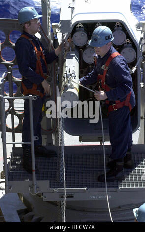 030316-N-2143T-003 At sea aboard USS Nimitz (CVN 68) Mar. 16, 2003 - Fire Controlman 3rd Class Richard Dillio, of New York, N.Y., and Fire Controlman 3rd Class Jarred Young, of Salt Lake City, Utah, load a RIM-116 Rolling Airframe Missile (RAM) into a Guided Missile Launcher System (GMLS) aboard USS Nimitz (CVN 68). A RAM is a 5-inch missile that utilizes Sidewinder missile technology for the warhead and rocket motor, and the Stinger missile's seeker-head. The launcher system comes in either a 21-round or an 11-round launcher. Nimitz Carrier Strike Group (CSG), Cruiser Destroyer Group Five (CC Stock Photo