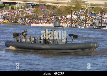 030412-N-9824J-004 Louisville, Ky. (Apr. 12, 2003) -- Louisville area residents lined the riverbanks of the Ohio River as a U.S. Navy Rigid Hull Inflatable Boat (RHIB) departs their pier to get in place for their special operations demonstration as part of the military demonstrations prior to Thunder Over Louisville (TOL), the worldÕs largest fireworks and pyrotechnics show. This marked the first time Navy special operations boats participated in TOL.  U.S. Navy photo by Chief Journalist Tom Jones.  (RELEASED) Rigid Hull Inflatable Boat Stock Photo