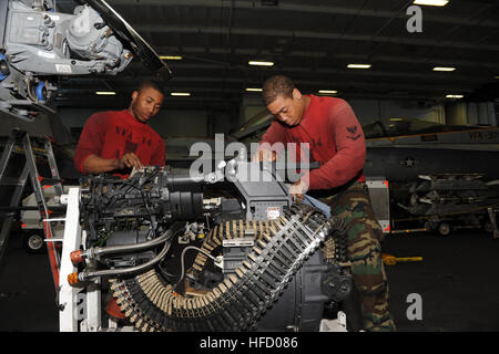 U.S. 5TH FLEET AREA OF RESPONSIBILITY (Jan. 19, 2013) Aviation Ordnanceman 3rd Class Dominic Sharkey, from Pine Bluff, Ark., and Aviation Ordnanceman 3rd Class Sherod Payne, from Columbus, Ohio, clean the internal 20 mm M61A2 lightweight Gatling gun from an F/A-18E Super Hornet assigned to the Tophatters of strike fighter squadron (VFA) 14 in the hangar bay of the aircraft carrier USS John C. Stennis (CVN) 74. John C. Stennis is deployed to the U.S. 5th Fleet area of responsibility conducting maritime security operations, theater security cooperation efforts and support missions for Operation  Stock Photo