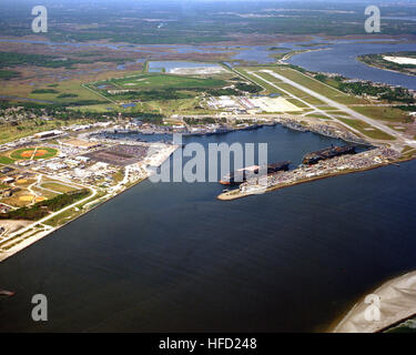 An aerial view, looking southwest, showing the harbor at the naval station with two aircraft carriers, the USS CONSTELLATION (CV-64) and the USS SARATOGA (CV-60), moored at the carrier pier.  To the upper right in the photograph is the main runway at Naval Air Station Mayport. Aerial NS Mayport with CV-60 and CV-64 1993 Stock Photo