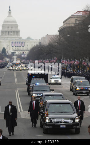 Flanked by Secret Service agents, US President George W. Bush and First Lady,  Laura Bush travel the inaugural parade route inside an armored limousine headed toward the White House after renewing the oath of office earlier in the day at the nation's Capitol with thousands of spectators in attendance. Secret-Service 2005 Inaugural-Parade Stock Photo
