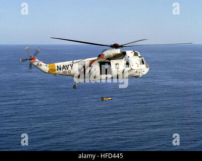 An air-to-air right side view of an SH-3 Sea King helicopter from Helicopter Anti-submarine Squadron 10 (HS-10), as it drops an AN/ASQ-81V Airborne Magnometer into the water during an anti-submarine warfare exercise. SH-3H of HS-10 in flight with lowered MAD sensor 1984 Stock Photo