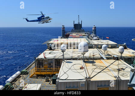 A helicopter approaches the container ship MV Cape Ray (T-AKR 9679) in the Mediterranean Sea to drop off cargo Aug. 4, 2014. The U.S. government-owned Cape Ray was modified and deployed to the eastern Mediterranean Sea to dispose of Syrian chemical agents in accordance with terms Syria agreed to in late 2013. (U.S. Navy photo by Mass Communication Specialist Seaman Desmond Parks/Released) Syrian chemical agents destruction 140804-N-XB010-003 Stock Photo