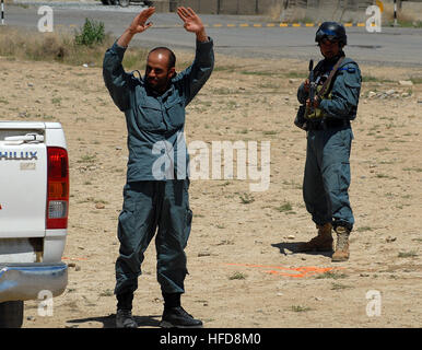 100420-N-9594C-013 KABUL, Afghanistan (April 20, 2010) – An Afghan National Civil Order Police (ANCOP), Non-Commissioned Officer, right, guards a driver who was “taken into custody” during traffic control point training at a Kabul facility.  Members of the elite police force received training in traffic control and communications gear as they prepare for operations in Afghanistan. (US Navy Photo by Chief Mass Communication Specialist F. Julian Carroll/Released) Afghan National Civil Order Police officers train for operations in Afghanistan. (4537275065) Stock Photo
