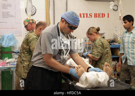 U.S. Army Maj. Jason Hawksworth, front, a general surgeon, and team members of the 541st Forward Surgical Team (FST) (Airborne), perform an assesment on a wounded Afghan National Policeman at Forward Operating Base (FOB) Farah, Nov. 20.  The policeman was treated at FOB Farah by the FST following a targeted Taliban attack that killed a former Taliban who left the insurgency to join the Afghan National Police.  The policeman was treated and medically evacuated for further care.  (U.S. Navy photo by HMC Josh Ives/released) U.S. coalition forces treat Afghan National policeman at FOB Farah 121120 Stock Photo