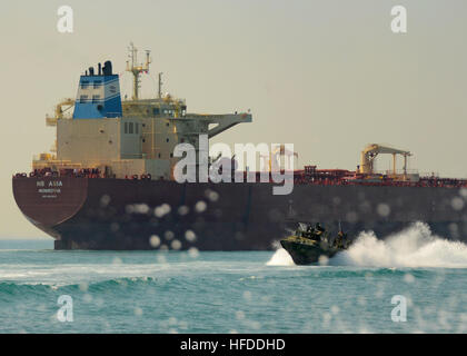 U.S. Sailors aboard a riverine command boat (RCB) assigned to Commander Task Group (CTG) 56.7 pass an oil tanker after completing a live-fire exercise in the Persian Gulf Dec. 12, 2013. RCB's provided a multimission platform for the U.S. 5th Fleet area of responsibility by focusing on maritime security operations, maritime infrastructure protection and theater security cooperation efforts, as well as conduct offensive combat operations. (U.S. Navy photo by Mass Communication Specialist 1st Class Corey Green/Released) U.S. Sailors aboard a riverine command boat (RCB) assigned to Commander Task  Stock Photo