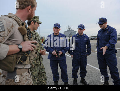 VIRGINIA BEACH, Va. (Nov. 15, 2013) - Explosive Ordnance Disposal Group (EODGRU) 2 Sailors discuss conventional and special operations equipment with U.S. Coast Guard Liaison Officers during a visit to Navy Expeditionary Combat Command (NECC) at Joint Expeditionary Base Little Creek-Fort Story.  Coast Guard members visited NECC to get an overview of NECC commands and discuss expeditionary capabilities. NECC serves as the single functional command in control of manning, training, equipping and organizing Navy expeditionary forces.  (U.S. Navy Photo by Mass Communication Specialist 3rd Class Lau Stock Photo