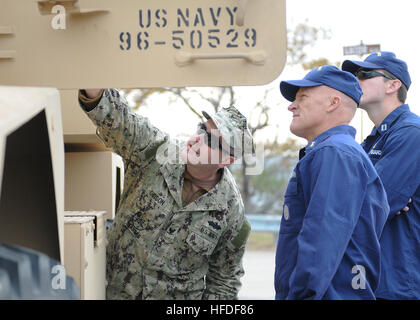 VIRGINIA BEACH, Va. (Nov. 15, 2013) - Explosive Ordnance Disposal Technician 3rd Class Chris Gibson, assigned to Explosive Ordnance Disposal Group (EODGRU) 2, discusses the capabilities of the Mine Resistant Ambush Protected Vehicle (MRAP) with U.S. Coast Guard Liaison Officers during a visit to Navy Expeditionary Combat Command (NECC) at Joint Expeditionary Base Little Creek-Fort Story.  Coast Guard members visited NECC to get an overview of NECC commands and discuss expeditionary capabilities. NECC serves as the single functional command in control of manning, training, equipping and organiz Stock Photo