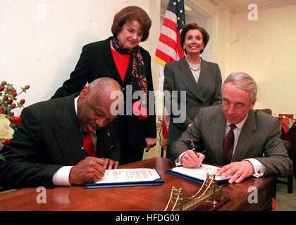 020123-N-5636P-001 Capitol Hill, Washington, D.C. (Jan. 23, 2002) -- Secretary of the Navy the Honorable Gordon England (right), signs an agreement with San Francisco Mayor Willie Brown (left), transferring the former Hunter's Point Naval Ship Yard to the city of San Francisco, CA, during a ceremony held in the office of Congresswoman Nancy Pelosi (D-Calif), (top right).  Senator Dianne Feinstein (D-Calif), (top left) helped sponsor a bill to clean up Hunter's Point before its transfer. The agreement allows the city to develop parcels of ready land, while clean up of the facility continues.  U Stock Photo