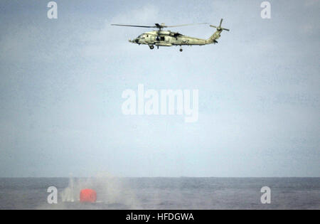 020507-N-9849W-001 At sea aboard USS Kitty Hawk (CV 63) May 7, 2002 -- A helicopter assigned to the ÒChargersÓ of Helicopter Anti-Submarine Squadron (HS-14) conducts .50 caliber machine gun target practice.  Ships at sea conduct live fire training using brightly colored inflatable targets referred to as ÒKiller TomatosÓ.  Kitty Hawk is providing a forward presence in the Asian Pacific region, conducting training and exercises with regional allies.  Kitty Hawk is the NavyÕs only permanently forward deployed aircraft carrier, and is homeported in Yokosuka, Japan.  U.S. Navy photo by Photographer Stock Photo