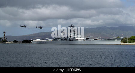 Two helicopters from the 'Easy Riders' of Helicopter Antisubmarine Squadron Light 37, perform a fly-over between Kilo pier and the USS Missouri and USS Arizona Memorials at the beginning of a change of command ceremony in which Rear Adm. Townsend G. Alexander was relieved by Rear Adm. Dixon R. Smith as commander, Navy Region Hawaii and commander, Naval Surface Group Middle Pacific at Naval Station Pearl Harbor. 'Easy Riders' helicopters perform fly-over at change of command ceremony 124992 Stock Photo