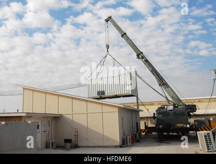 KANDAHAR, Afghanistan--A crane lifts a power supply container that was occupying the space where a new medical operation facility will be put in place at the ROLE 3 Hospital near Kandahar Air Field on February 3, 2008. The one-day project is a joint venture with the Task Forces operating in the ISAF RC South area of operation. The new operation room is expected to be fully operational later in the week. ISAF photo by U.S. Navy Petty Officer 2nd Class Aramis X. Ramirez (RELEASED) Armored crane moves shipping containers while expanding the ROLE 3 Hospital on Kandahar Airport -b Stock Photo