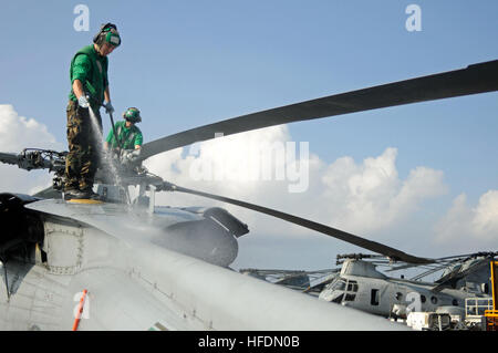 U.S. 5TH FLEET AREA OF RESPONSIBILITY (Dec. 2, 2012) – Aviation Machinist’s Mate 3rd Class Nathan Morris washes an MH-60S Knighthawk helicopter, assigned to the “Wild Cards” of Combat Helicopter Squadron 23 aboard amphibious assault ship USS Peleliu (LHA 5). Peleliu is the flagship for the Peleliu Amphibious Ready Group and along with the embarked 15th Marine Expeditionary Unit are deployed in support of maritime security operations and theater security cooperation efforts in the U.S. 5th Fleet area of responsibility. (U.S. Navy photo by Mass Communication Specialist 2nd Class Daniel Viramonte Stock Photo