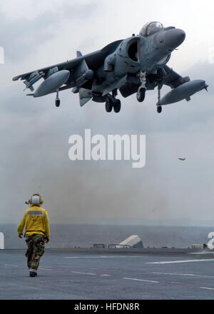 080429-N-5253W-002  SOUTH CHINA SEA (April 29, 2008) Aviation Boatswain's Mate (Handling) 3rd Class Quoc Nguyen looks on as an AV-8B Harrier, assigned the 'Nightmares' of Marine Attack Squadron (VMA) 513, lands aboard the flight deck of the forward-deployed amphibious assault ship USS Essex (LHD 2). Essex is the lead ship of the only forward-deployed amphibious force. U.S. Navy photo by Mass Communication Specialist 3rd Class Gabriel S. Weber (Released) AV-8B Harrier II landing on USS Essex ID 080429-N-5253W-002 Stock Photo