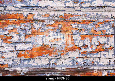 Image of dry and cracked paint falling off wooden planks. Stock Photo