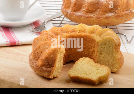 freshly and warm gugelhupf on wooden board and one on a cooling rack Stock Photo