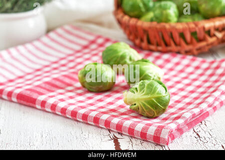 Fresh raw brussel sprouts on white rustic wooden background Stock Photo