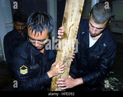 40603-N-4104L-005 Singapore (Jun. 3, 2004) - Lt. j.g. Chris Cortez, Repair Division Officer assigned to the guided missile destroyer USS Russell (DDG 59), and a Republic of Singapore Navy (RSN) Sailor use shoring material to repair damage during a flooding scenario at a RSN damage control wet trainer. The training was a Cooperation Afloat Readiness and Training (CARAT) event. CARAT is a regularly scheduled series of bilateral military exercises designed to enhance the interoperability of the respective sea services. U.S. Navy photo by Chief Journalist Melinda Larson (RELEASED) US Navy 040603-N Stock Photo