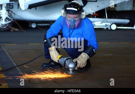040604-N-9319H-027 South Atlantic Ocean (June 4, 2004) - Airman Carmeia Wetchie, from Firth, Idaho, grinds non-skid from a weapons elevator door in the hangar bay aboard USS Ronald Reagan (CVN 76) in preparation for resurfacing. The aircraft carrier with embarked Carrier Air Wing One One (CVW-11) is underway in the South Atlantic Ocean circumnavigating South America on her way to her new homeport of San Diego, Calif. U.S. Navy photo by Photographer's Mate 3rd Class Angel G. Hilbrands (RELEASED) US Navy 040604-N-9319H-027 Airman Carmeia Wetchie, from Firth, Idaho, grinds non-skid from a weapons Stock Photo
