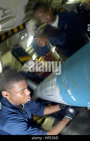 040810-N-9458H-036 Pacific Ocean (Aug. 10, 2004) - Airman Takiya Minter from Brooklyn, N.Y., and Airman Jonathan Gary from Oklahoma City assemble a Mark 83 general-purpose practice bomb in a weapons magazine aboard USS Kitty Hawk (CV 63). The pins ensure safe movement and loading of ordnance. Currently underway in the Seventh Fleet area of responsibility (AOR), Kitty Hawk demonstrates power projection and sea control as the world's only permanently forward-deployed aircraft carrier, operating from Yokosuka, Japan. U.S. Navy photo by Photographer's Mate 3rd Class Patrick Hutchison (RELEASED) US Stock Photo