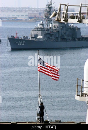 050419-N-7526R-017 Yokosuka, Japan (April 19, 2005) - The Japan Maritime Self-Defense Force destroyer Shirayuki (DD 123) travels through Yokosuka Bay as a Sailor aboard USS Blue Ridge (LCC 19) lowers the Ensign, during the shifting of colors as the ship gets underway. Blue Ridge recently completed Final Evaluation Problem (FEP). FEP is designed to demonstrate the ship's ability to conduct multiple simultaneous combat missions, support functions and service complex casualty control simulations under stressful conditions. Blue Ridge is the U.S. Seventh Fleet command ship. U.S. Navy photo by Jour Stock Photo