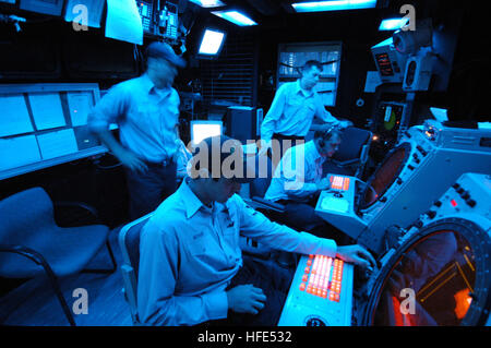 An Air Traffic Controller aboard USS Nassau (LHA 4) monitors aircraft approaching during a FAA certification for the Tactical Air Navigation system. The system guides planes to landing areas using radio waves, providing pilots with distance and directional information for safe landings aboard the ship. Stock Photo