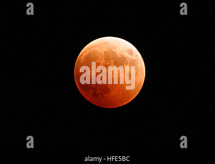 041027-N-9500T-001 Naval Air Station Whidbey Island, Wash. (Oct. 27, 2004) - The moon turns red and orange during a total lunar eclipse. With the Earth passing between the sun and the moon, the only light hitting the full moon was from the home planet's sunrises and sunsets, resulting in the orange and red hue. The next total lunar eclipse won't be till March 2007. U.S. Navy photo by Photographer's Mate 2nd Class Scott Taylor (RELEASED) US Navy 041027-N-9500T-001 The moon turns red and orange during a total lunar eclipse Stock Photo