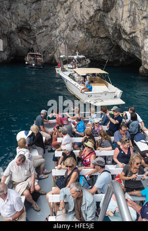 Line of tourists boats to famous  The Blue Grotto - a sea cave on the coast of the island of Capri, Bay of Naples, Italy, Europe Stock Photo