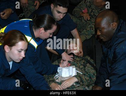 041118-N-5313A-009 Atlantic Ocean (Nov. 18, 2004) - Hospital Corpsman 3rd Class Melody Austin from Ponchatoula, La., second from left, explains to stretcher bearers how to control excess bleeding from an abdominal wound, during a mass causality exercise aboard the amphibious assault ship USS Kearsarge (LHD 3). The Kearsarge Expeditionary Strike Group (ESG) and the 26th Marine Expeditionary Unit (MEU) are conducting initial integrated training in preparation for an upcoming scheduled deployment. U.S. Navy photo by Photographer's Mate Airman Sarah E. Ard (RELEASED) US Navy 041118-N-5313A-009 Hos Stock Photo