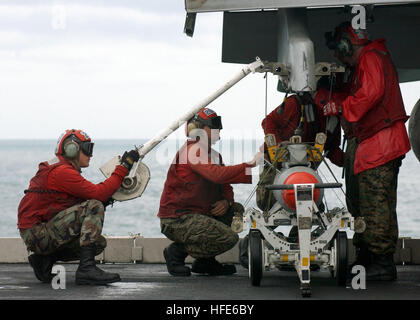 041201-N-5345W-056 Persian Gulf (Dec. 1, 2004) Ð U.S. Marines Corps Ordnancemen, assigned to the 'Silver Eagles' of Marine Fighter Attack Squadron One One Five (VMFA-115), hoist an AGM-65 Maverick laser-guided missile to a weapons pylon under the wing of one of their squadron's F/A-18A Hornets aboard the Nimitz-class aircraft carrier USS Harry S. Truman (CVN 75). The AGM-65 Maverick is an air-to-surface tactical missile designed for close air support, interdiction and defense suppression. It is effective against a wide range of tactical targets, including armor, air defenses, ships, ground tra Stock Photo