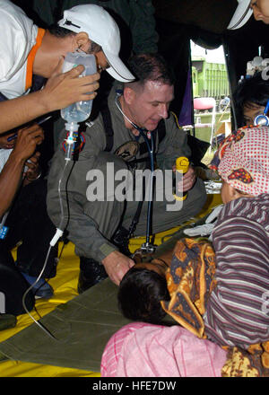 050103-N-9951E-100 Aceh, Sumatra, Indonesia (Jan. 3, 2005) - Lt. Mark Banks, of Savannah, Ga., tends to a patient flown-in by a U.S. Navy helicopter to a temporary triage site in Aceh, Sumatra. Medical teams from USS Abraham Lincoln (CVN 72), Carrier Air Wing Two (CVW-2) and the International Organization for Migration (IOM) set-up a triage site located on Sultan Iskandar Muda Air Force Base, in Banda Aceh, Sumatra. The two teams worked together with members of the Australian Air Force to provide initial medical care to victims of the Tsunami-stricken coastal regions. The Abraham Lincoln Carri Stock Photo