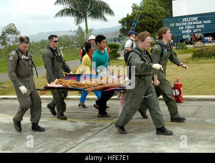 050103-N-9951E-115 Aceh, Sumatra, Indonesia (Jan. 3, 2005) - From left, Lt. Mark Banks, Chief Hospital Corpsman Jim Jones, Hospital Corpsman 1st Class Rebecca McClung, and Lt. Lisa Peterson, carry a patient on a stretcher flown-in by a U.S. Navy helicopter to a temporary triage site in Aceh, Sumatra. Medical teams from USS Abraham Lincoln (CVN 72), Carrier Air Wing Two (CVW-2) and the International Organization for Migration (IOM) set-up a triage site located on Sultan Iskandar Muda Air Force Base, in Banda Aceh, Sumatra. The two teams worked together with members of the Australian Air Force t Stock Photo